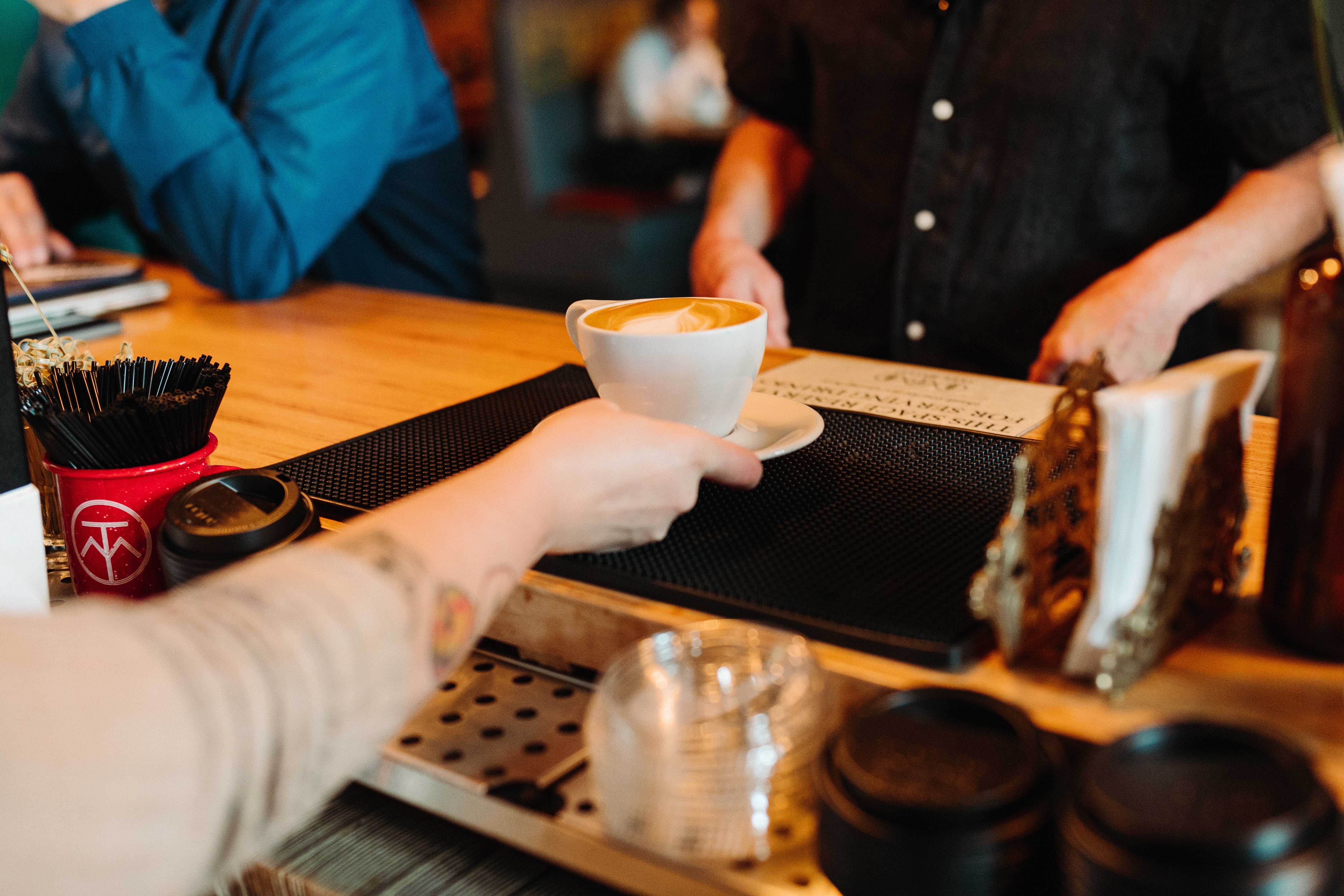 image of barista handing latte over to a customer