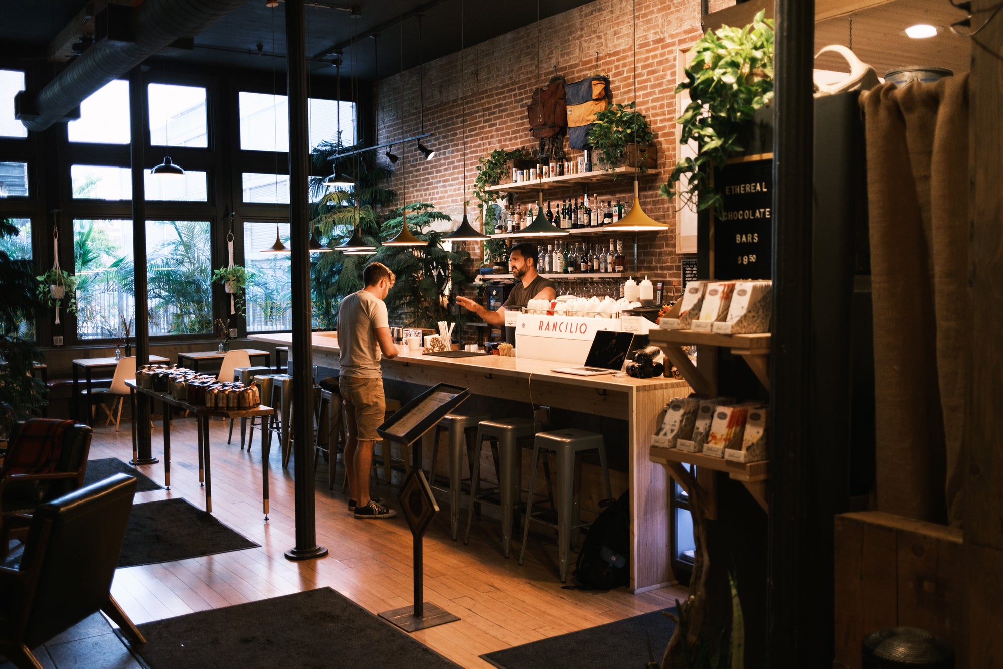 Image of a bartender speaking with a customer over the bar at Thou Mayest River Quay