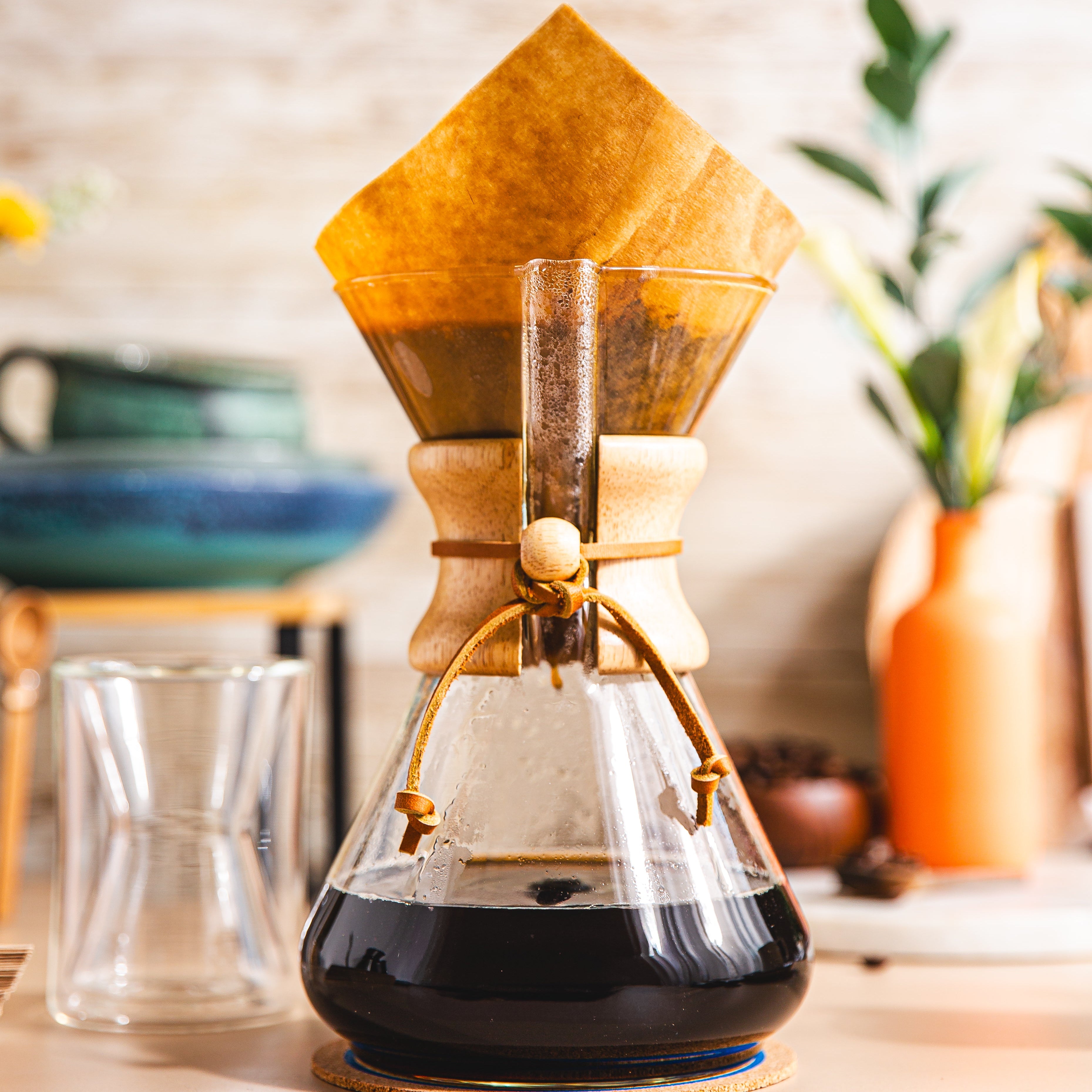 Chemex coffee maker with a paper filter on a wooden surface.